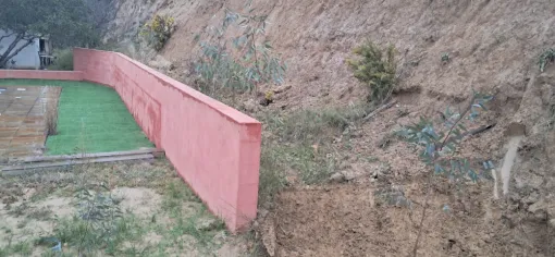 photo prise avant d'effectuer le terrassement. On distingue la terre à enlever derrière le mur